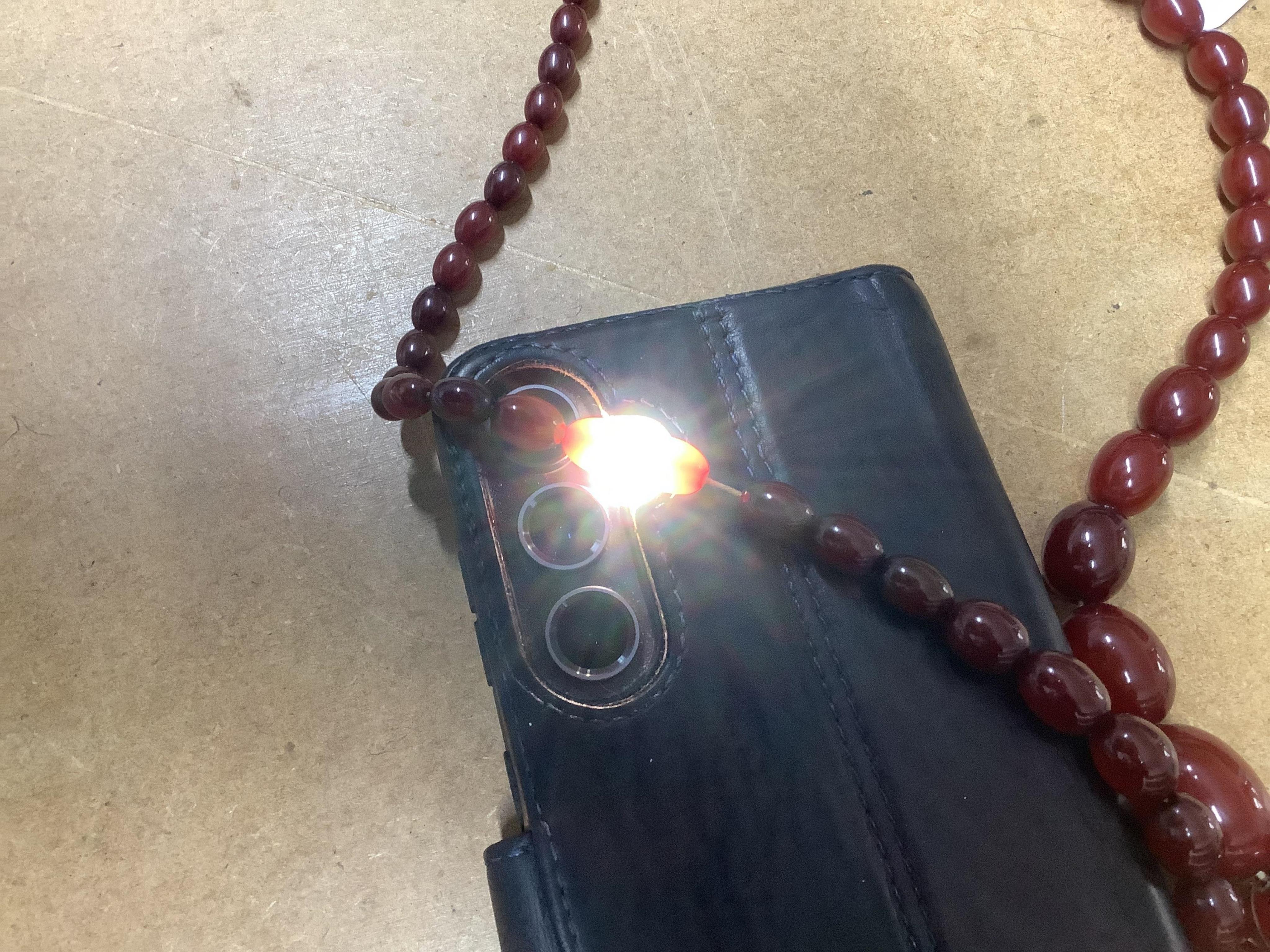 A cherry-coloured bakelite simulant amber necklace, composed of graduated beads measuring approximately 8-28mm, length 86cm, gross weight approximately 61 grams